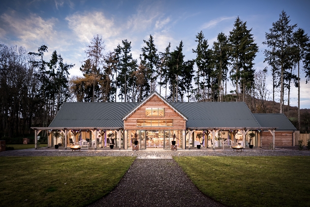 The exterior of a barn with a grey roof